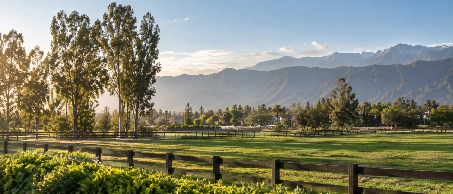 Representative Chino, California landscape with open fields, ranch fencing, trees, and distant mountains
