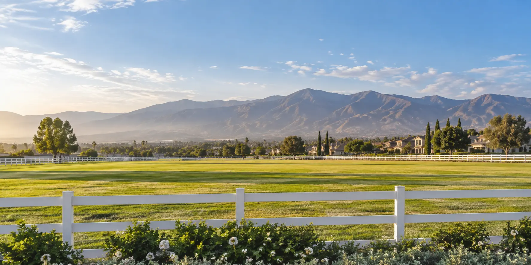 Representative Eastvale, California landscape with open fields, white ranch fencing, and distant mountains